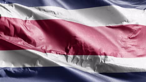 bandera textil de costa rica ondeando en el bucle del viento. bandera costarricense balanceándose en la brisa. tejido textil de tela. fondo de relleno completo. bucle de 10 segundos.