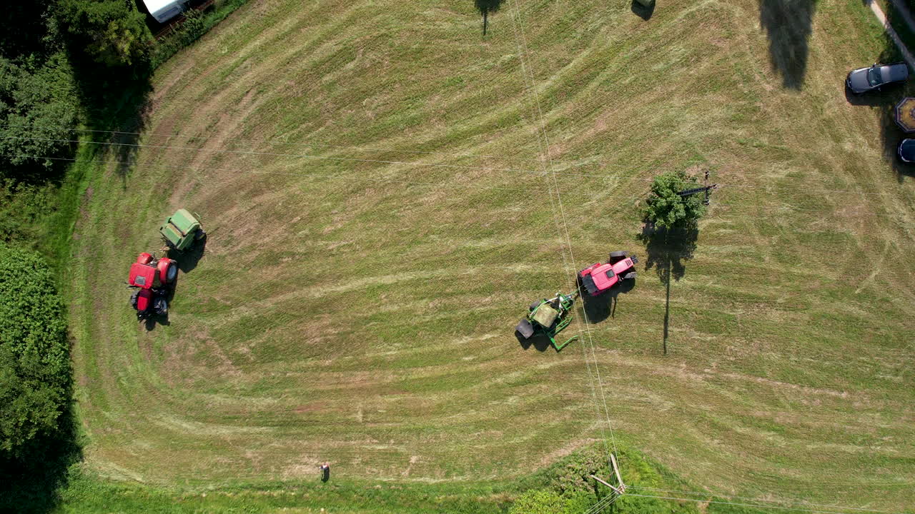 녹지에서 일하는 농업 기계 수확, 트랙터 및 건초 더미 기계는 농업 농지에서 수확하고, 농장 농업 작업의 공중 하향식 전망