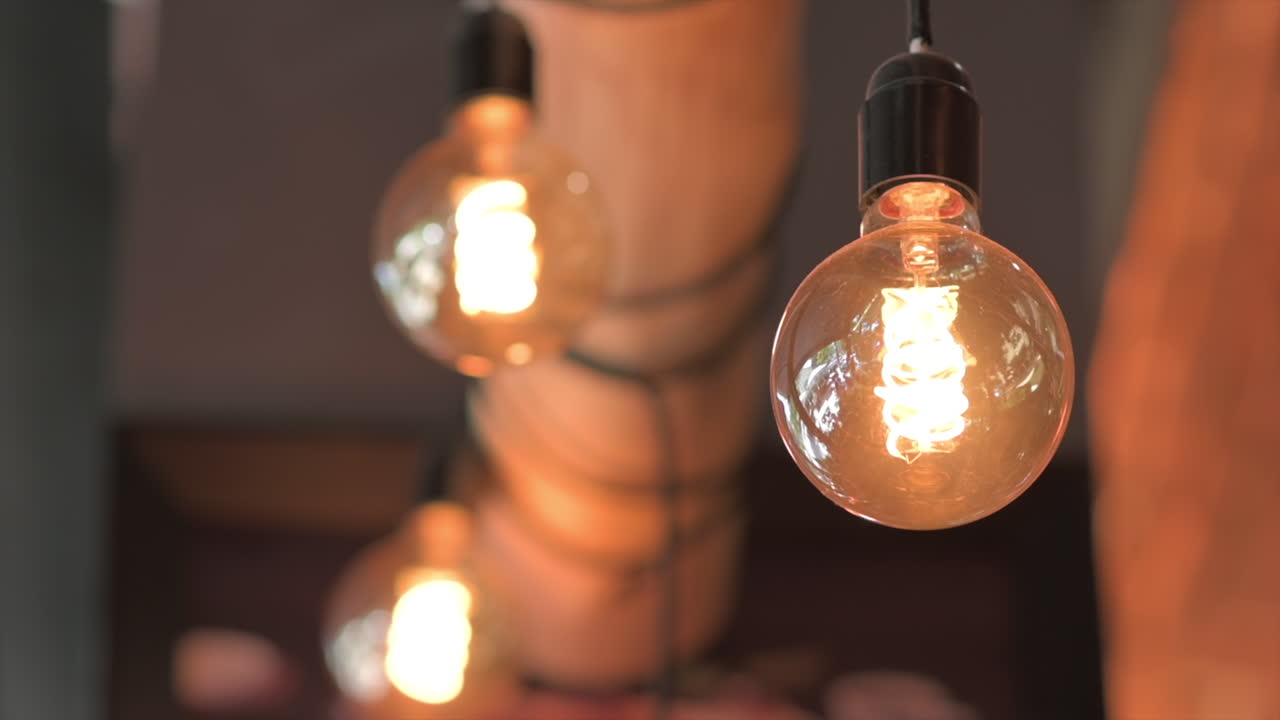 A cozy, dimly-lit setting with vintage-style filament light bulbs hanging from the ceiling