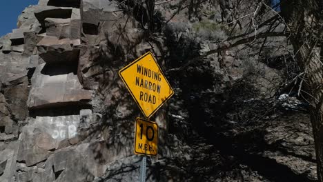 "Winding-Narrow-Road"-sign-along-a-high-desert-cliff-road-in-the-Rocky-Mountains-of-the-Western-United-States