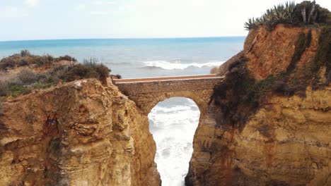 man made arch bridge, praia dos estudantes beach, lagos, portugal