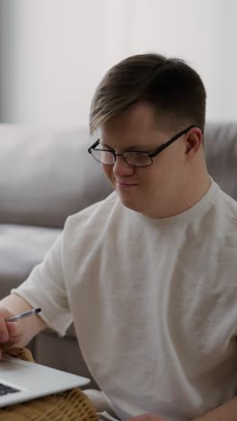 young adult with down syndrome working on a laptop