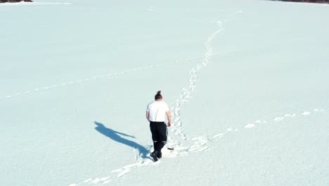 Man-Running-In-The-Snow-Towards-Fishing-Hole