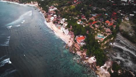 Beautiful-Bingin-beach-with-exotic-cliffs-houses-and-hotel-located-in-Bali,-Indonesia