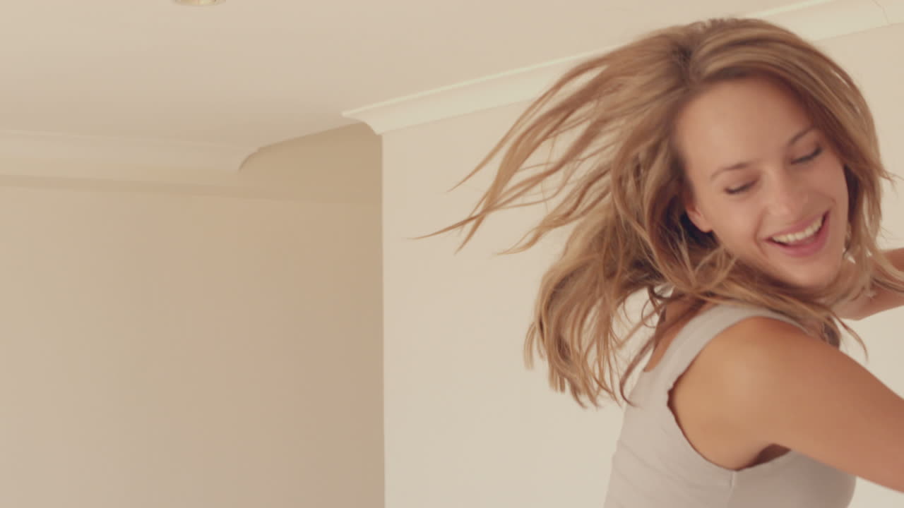 Bella donna che salta sul letto