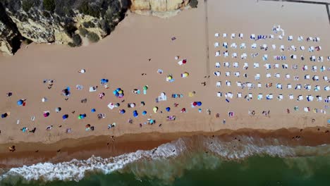 Drone-shot-of-the-beach-and-the-waves-hitting-land-in-Albufeira