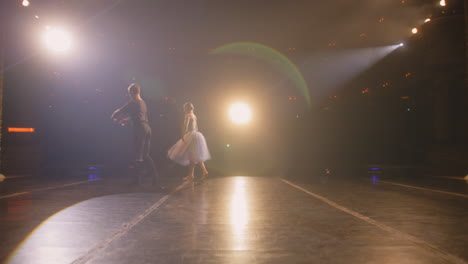 ballet dancers come out and perform dance curtains open ballet dancers come out and perform dance on classic theater stage illuminated by spotlights dance partners practice at choreography rehearsal for theatrical ballet performance