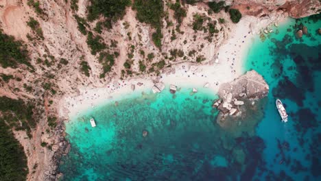 Antena-De-Arriba-Hacia-Abajo-De-La-Playa-Tropical-En-La-Costa-Rocosa-Con-Mar-Turquesa,-Cerdeña