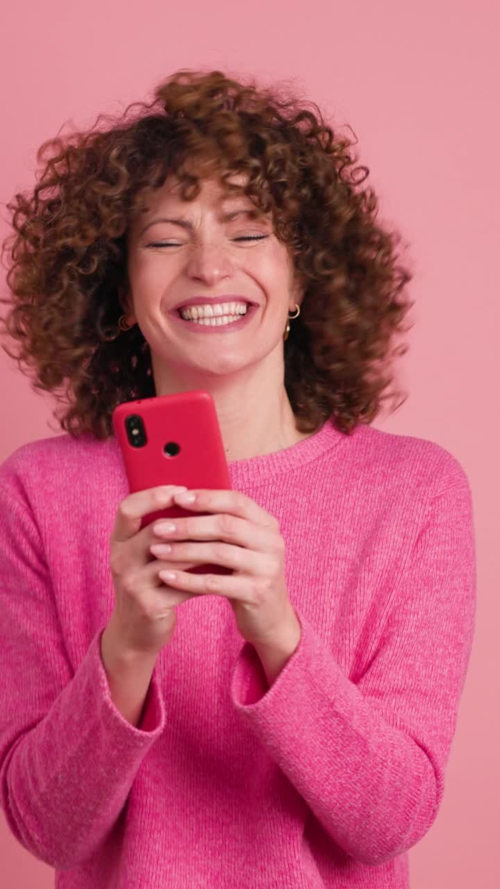 Successful woman using mobile phone in studio. Vertical footage