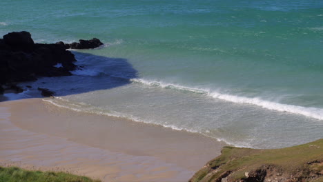 Vista-Mirando-Hacia-Abajo-Y-A-Través-De-Una-Playa-De-Cornualles-Con-Olas-Y-Rocío-Marino,-Tiro-Estático