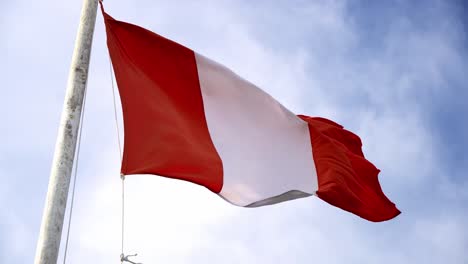 peruvian flag waving on a windy day in daytime, up-close blue skies