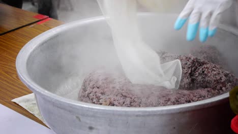 bolsa fresca de arroz morado caliente humeante con punta en un tazón grande de plata