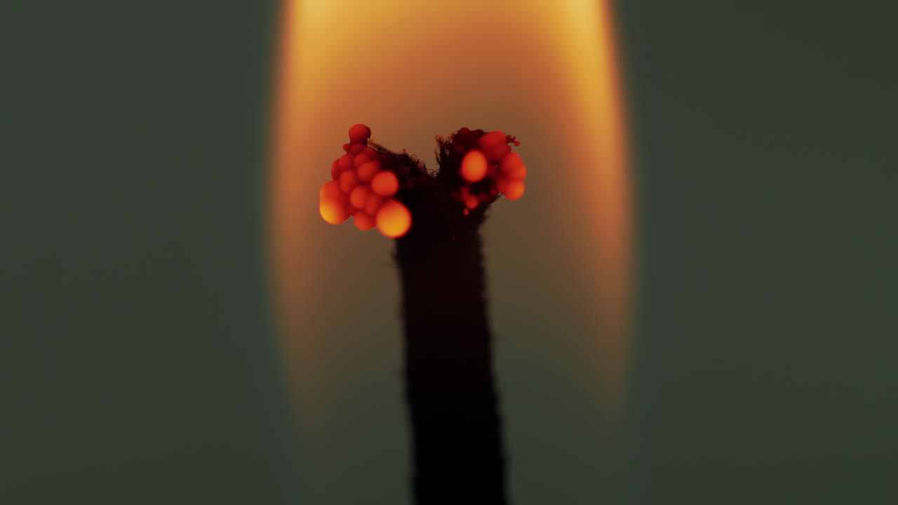 toma macro de estudio: la mecha de la vela se divide en la parte superior, la quema y la llama parpadean por el movimiento del viento