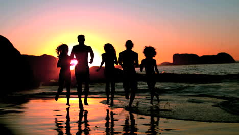 Friends-running-into-the-sea-under-the-dusk