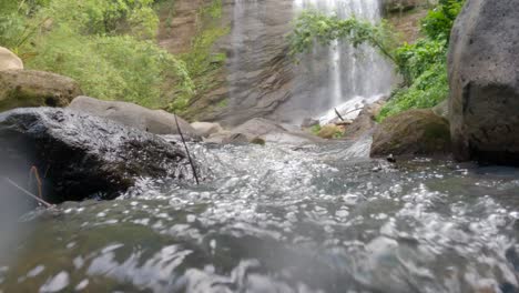 una vista de ángulo bajo del agua en el fondo de una cascada en la jungla