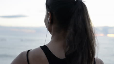 hermoso retrato de una mujer mirando el océano escuchando música