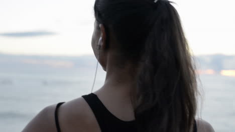 beautiful woman portrait looking at ocean view listening music