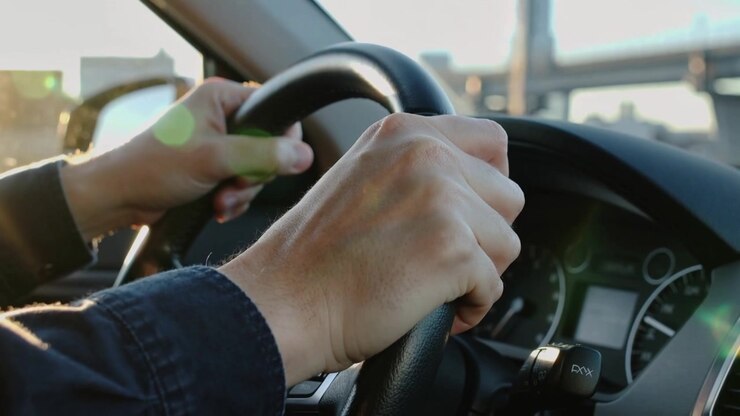 Avvicinandosi a un cavalcavia, mentre le mani sul volante regolano la presa per il controllo sulla strada, con volante in pelle