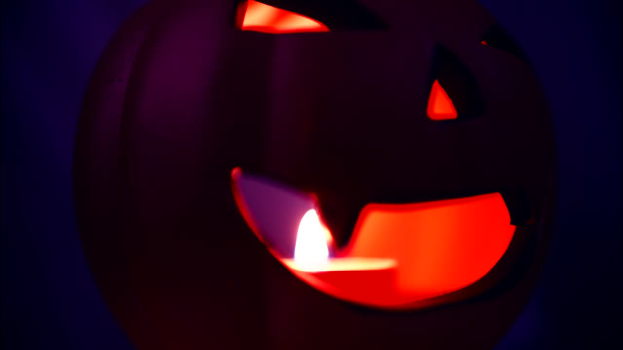 Primo piano di una zucca di Halloween luminosa con candela
