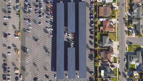 Lapso-De-Tiempo-De-Drones-De-Un-Gran-Estacionamiento-Al-Lado-De-Una-Zona-Residencial-Con-Techo-De-Panel-Solar-Como-Sombras-Para-Autos-Estacionados