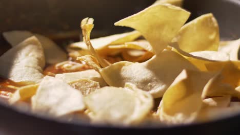 pouring tortilla chips into hot salsa bowl