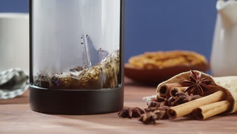 brewing black tea in a teapot close-up. drinking hot herbal drink on blue background