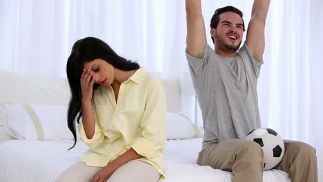 Woman-getting-annoyted-while-her-boyfriend-watching-football-match