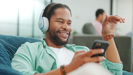 headphones, phone and black man on a sofa