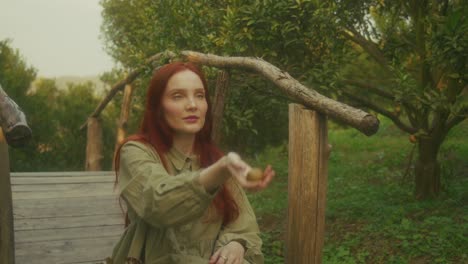 woman holding a kiwi in a garden