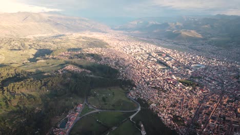 sunset shot of the city and forrest in cuzco peru