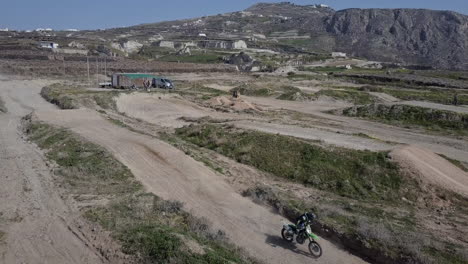 disparo de drones moviéndose hacia atrás con pilotos de motocross mientras saltan en la pista