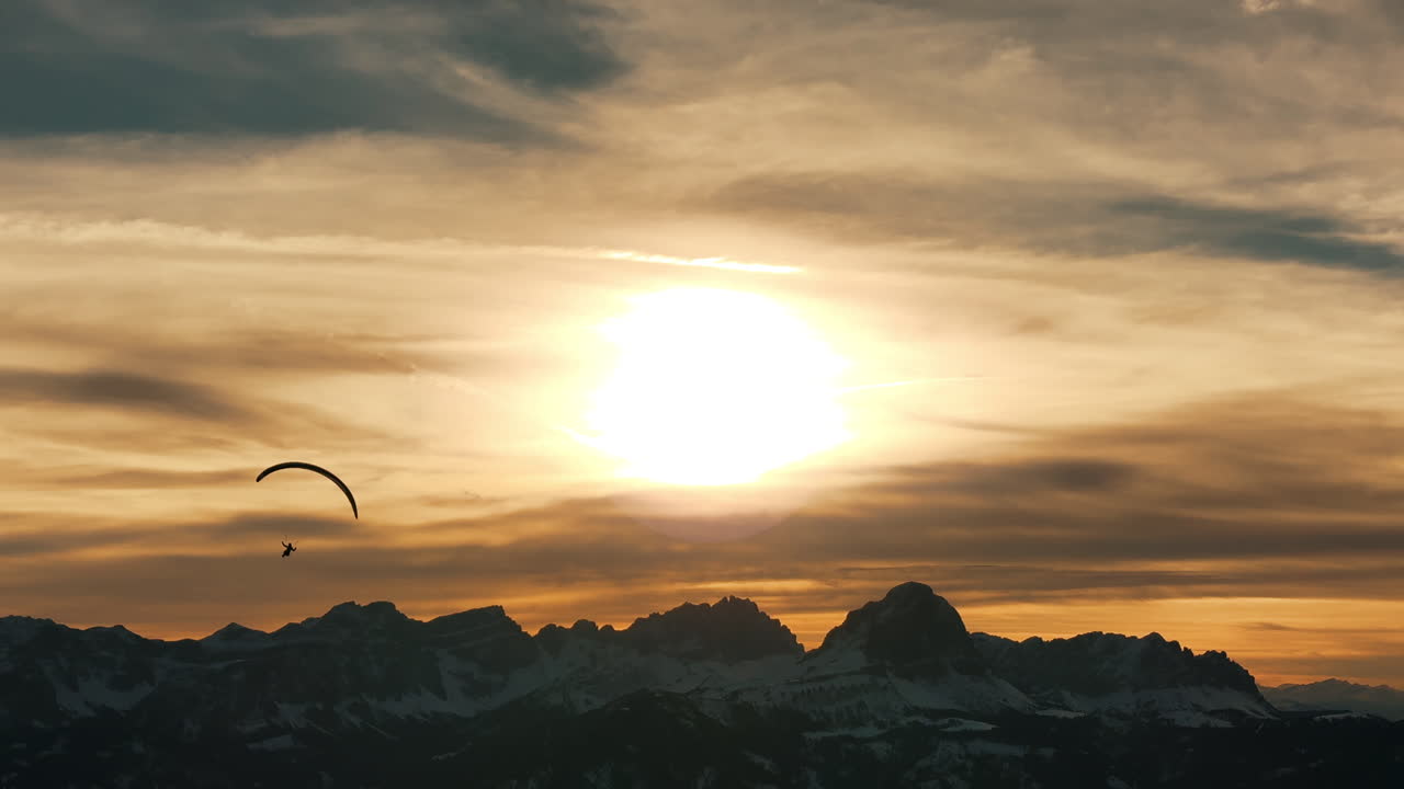 Paragliding over Snowy Alpine Mountains at Sunset