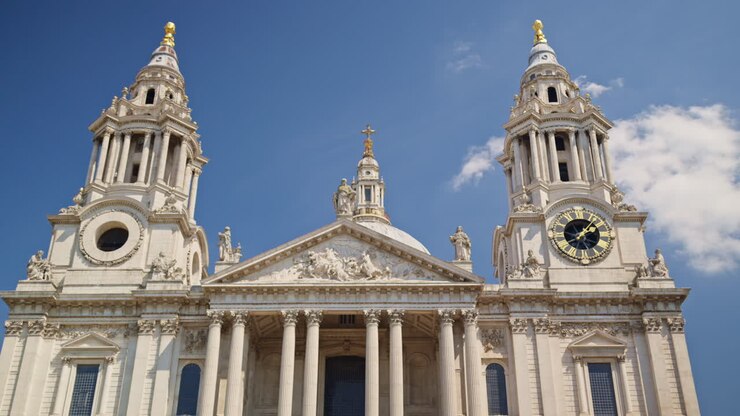The St. Paul's Cathedral rising above the trees with a clear blue sky in the background in London, England