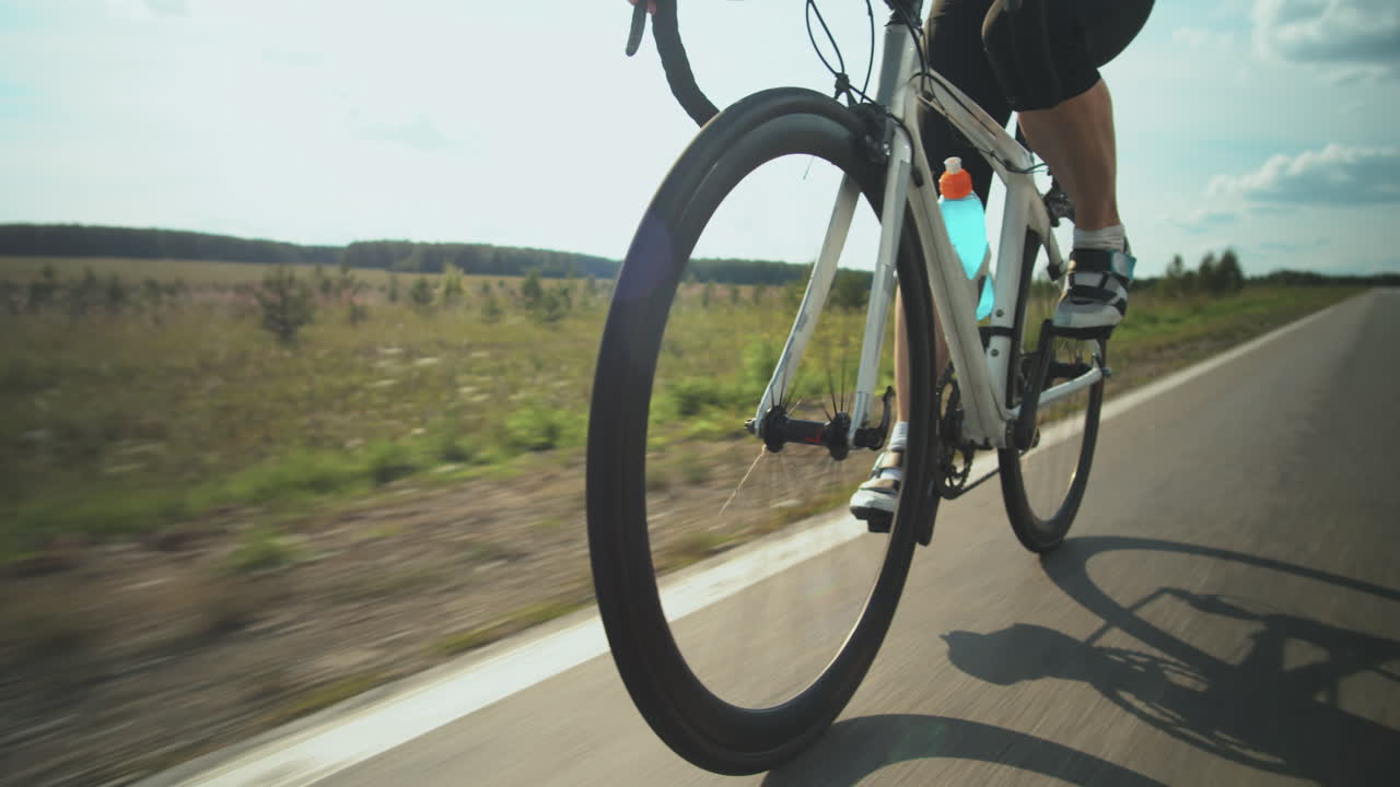 Sportiva che va in bicicletta su strada.