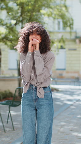 happy woman with curly hair laughing outdoors