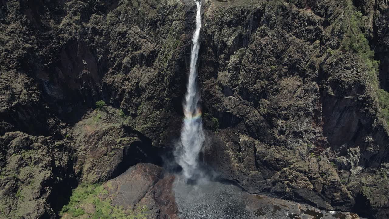 cámara lenta de la majestuosa cascada que cae sobre la piscina natural