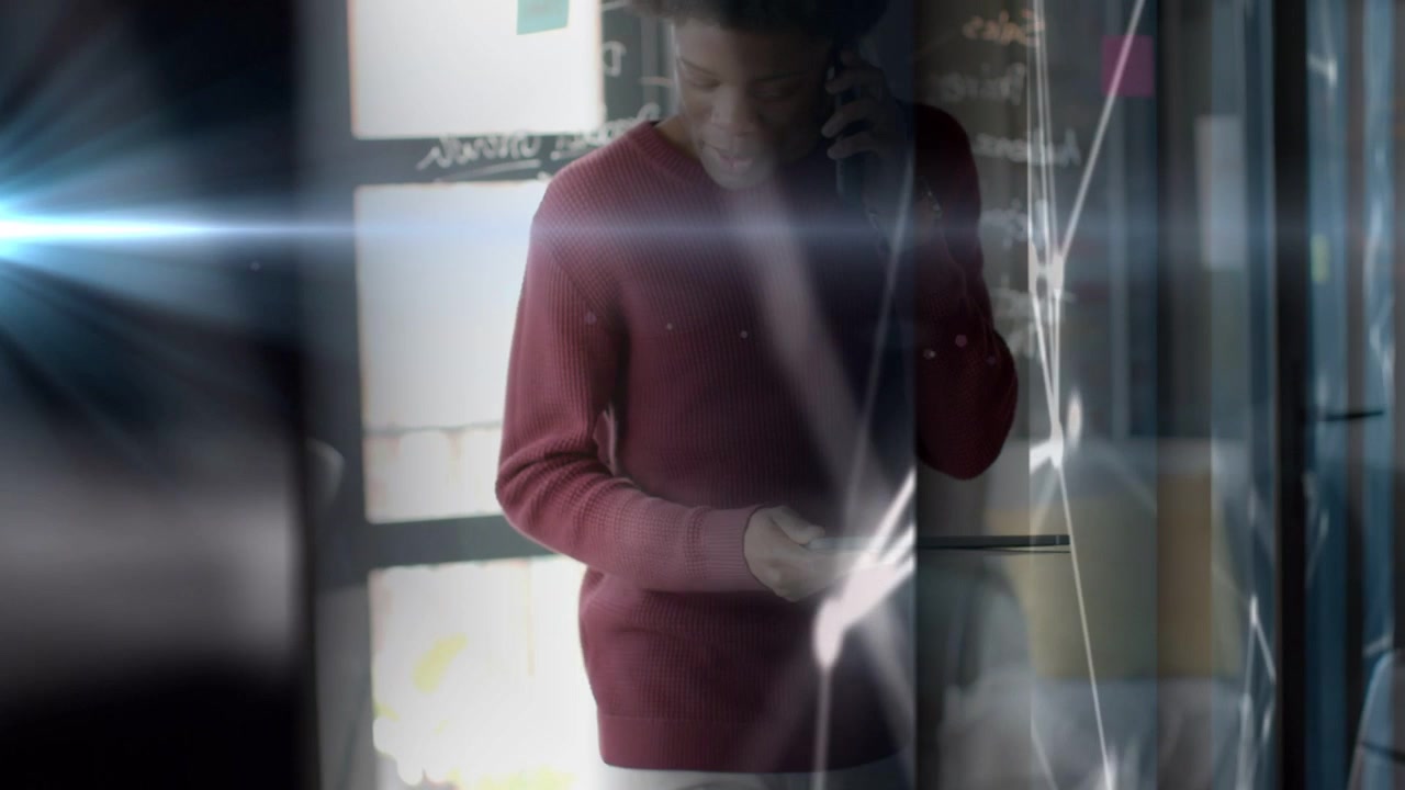 Mid-adult man receiving business call, holding tablet, tapping phone while streaks obscuring him