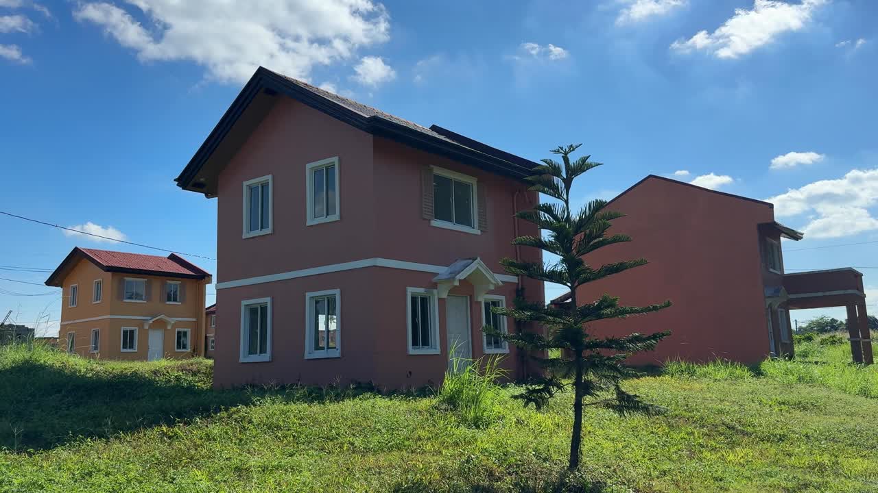 Pemandangan jalur setinggi tanah yang mengarah melewati deretan rumah jadi di lingkungan perumahan Camella Homes Alfonso Cavite Filipina.