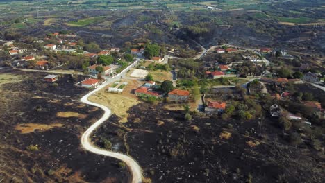 dramática imagen aérea de un pueblo rodeado de tierra quemada después de un incendio forestal en el norte de grecia, agosto de 2023