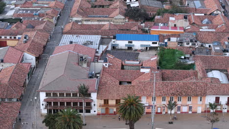 majestic aerial footage of catedral diocesana, zipaquirá. captures the calm plaza comuneros, red-tiled roofs, and vibrant streets, creating a serene sky perspective in soft daylight