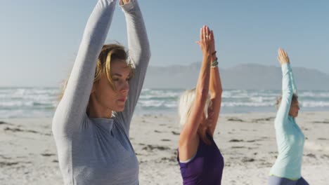 Mujeres-Atléticas-Realizando-Yoga-En-La-Playa