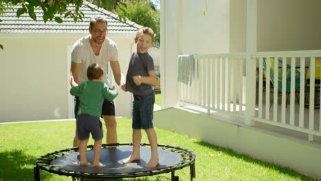 father playing with kids on trampoline 4k