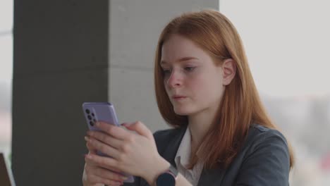 young woman is reading financial news in smartphone, surfing internet and application, female office worker