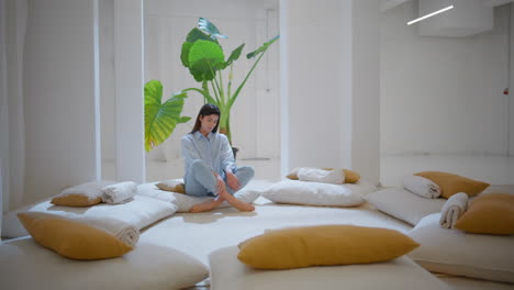 serene girl resting lotus position in cozy studio. calm woman contemplating