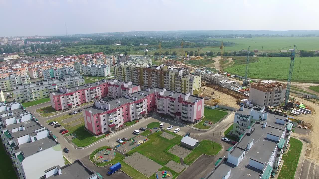 Flying above new residential complex in the city in summer. Panoramic top view of modern buildings built in the new district. Aerial view