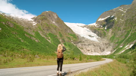 woman taking photo of a glacier in norway