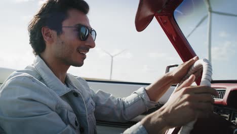 Side-view-video-of-happy-man-driving-a-stylish-car