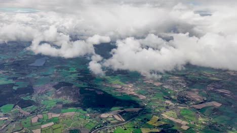 Ein-4K-Flug-über-Irlands-Grüne-Felder,-Die-Durch-Die-Wolken-Fallen