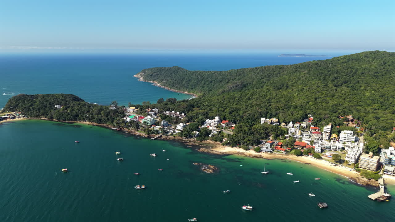A beautiful panoramic aerial view of the famous coastal town of Bombinhas in Santa Catarina, Brazil. The idyllic, calm bay is filled with boats on a sunny day