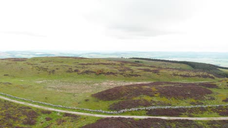 Straße-Entlang-Der-Felswand-In-Schottischen-Hochlandmooren,-Drohnenaufnahme